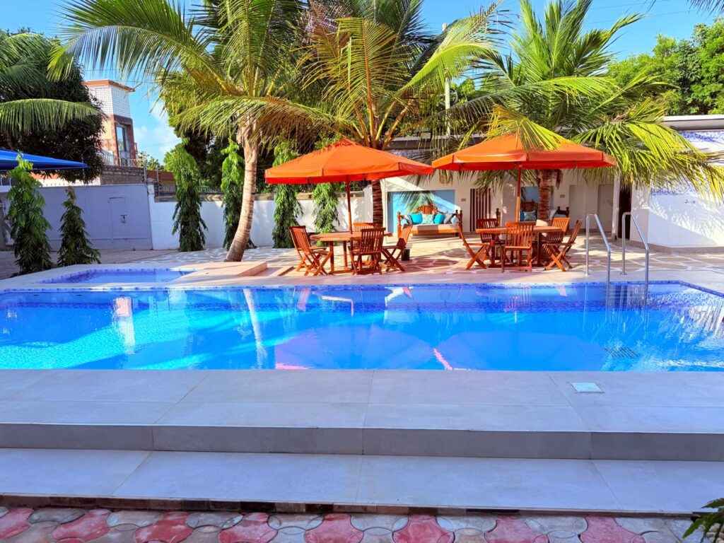 Private pool with orange umbrellas and teak dining sets