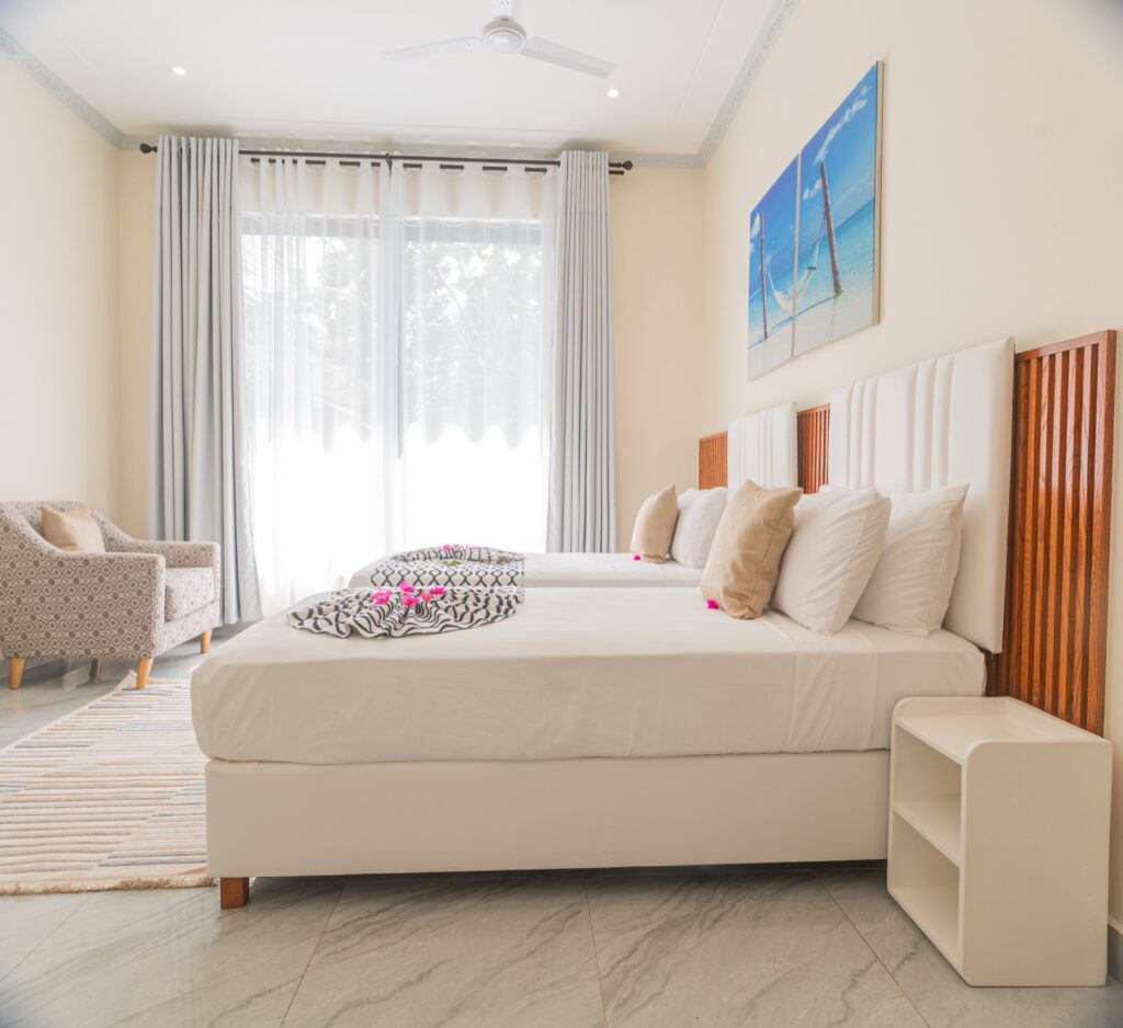 En-suite bedroom with upholstered bed and ocean artwork