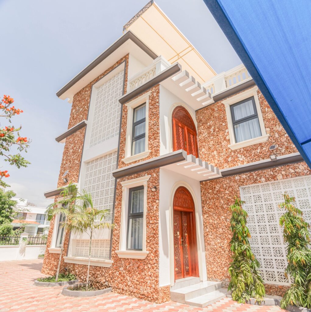 Ocean Villa distinctive coral stone facade with arched red doors